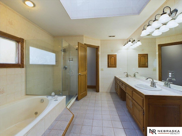 full bath with tile walls, a sink, a jetted tub, a stall shower, and double vanity
