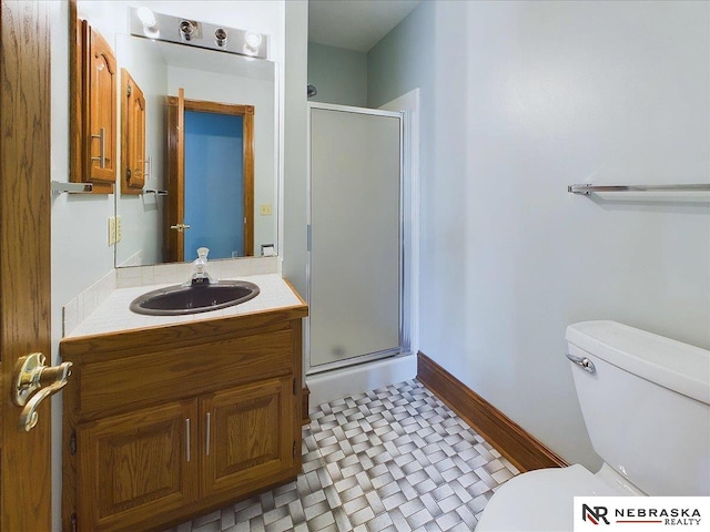 full bath featuring a stall shower, baseboards, toilet, and vanity