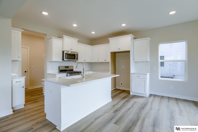 17547 Potter St, Bennington, NE 68007 - kitchen with decorative backsplash, white cabinets, light wood-style flooring, recessed lighting, and appliances with stainless steel finishes