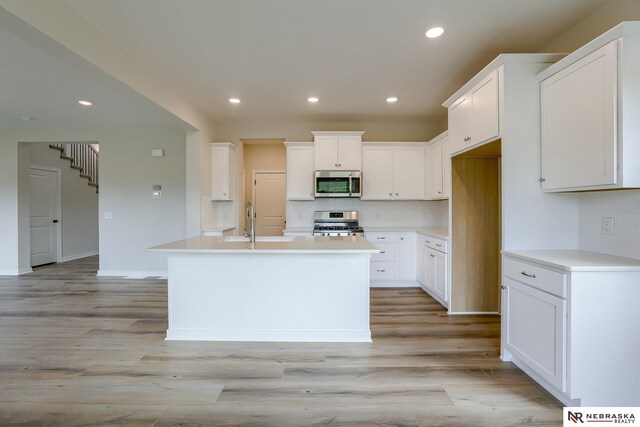 17547 Potter St, Bennington, NE 68007 - kitchen with decorative backsplash, recessed lighting, appliances with stainless steel finishes, white cabinetry, and light wood-type flooring