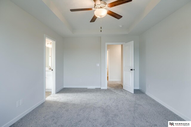 17547 Potter St, Bennington, NE 68007 - unfurnished bedroom featuring carpet, baseboards, connected bathroom, a ceiling fan, and a raised ceiling