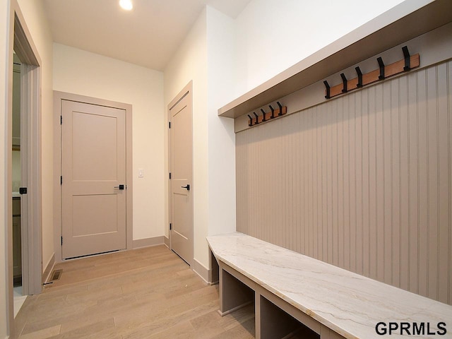 mudroom with light wood finished floors, baseboards, and visible vents