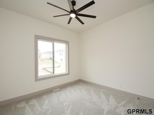 unfurnished room with baseboards, visible vents, carpet, and a ceiling fan