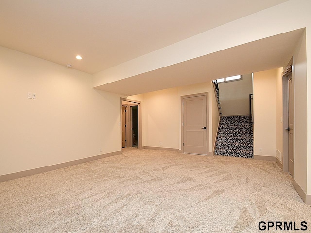 spare room featuring baseboards, recessed lighting, and light colored carpet