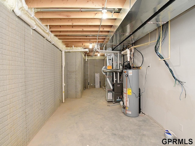 unfinished basement featuring gas water heater and brick wall