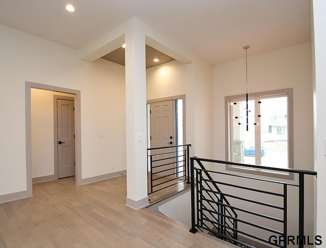 hall featuring baseboards, an upstairs landing, recessed lighting, and light wood-type flooring