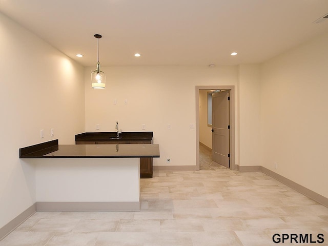 kitchen with baseboards, dark countertops, recessed lighting, and a peninsula
