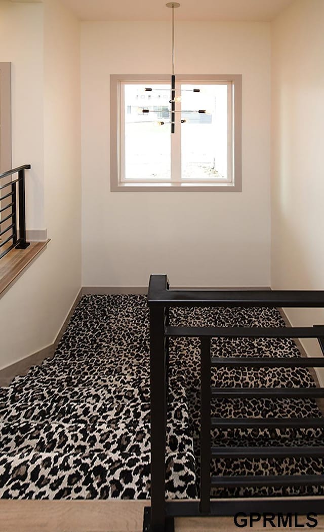 stairway with baseboards and carpet flooring