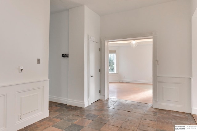 spare room with stone finish flooring, baseboards, and visible vents