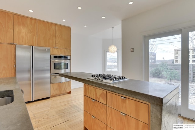 kitchen featuring a warming drawer, recessed lighting, light wood finished floors, modern cabinets, and appliances with stainless steel finishes