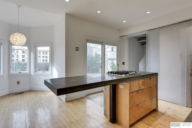 kitchen with stainless steel gas stovetop, visible vents, baseboards, recessed lighting, and light wood-style floors