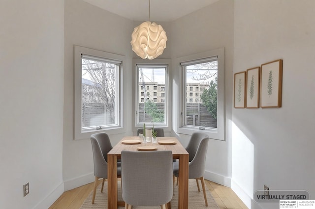 dining room featuring baseboards and light wood-style floors