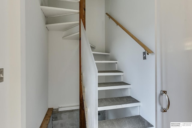 stairs featuring a baseboard heating unit