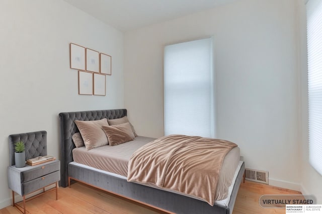bedroom featuring light wood-style flooring, baseboards, and visible vents