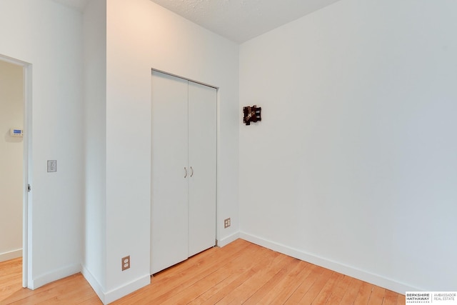 unfurnished bedroom featuring a closet, visible vents, baseboards, and light wood-type flooring
