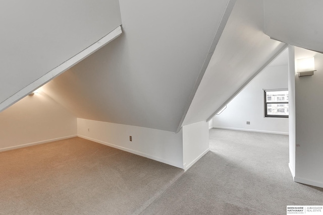 additional living space with carpet floors, baseboards, and lofted ceiling