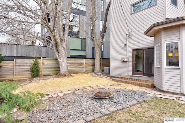 exterior space with cooling unit, a fire pit, and fence