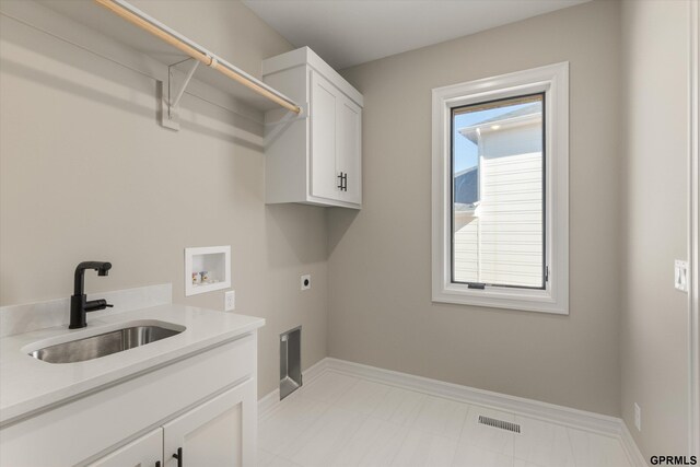 clothes washing area with a sink, washer hookup, hookup for an electric dryer, visible vents, and cabinet space