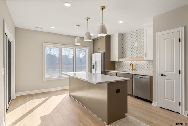 kitchen with a sink, dishwasher, decorative backsplash, wood tiled floor, and fridge with ice dispenser