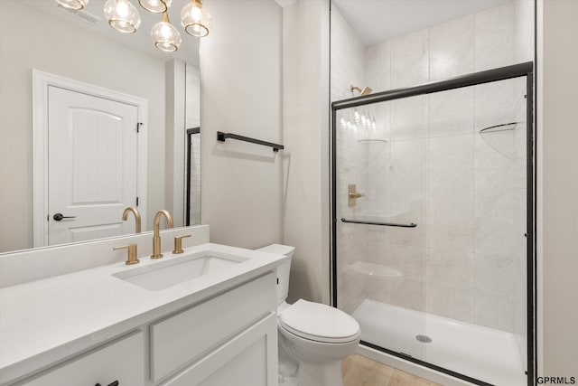 bathroom featuring a shower stall, visible vents, toilet, and vanity