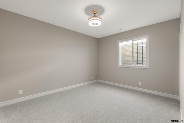 unfurnished room featuring light colored carpet, visible vents, and baseboards
