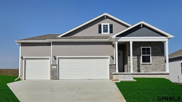 17650 Portal St, Omaha, NE 68136 - view of front of house with stone siding, a front yard, and concrete driveway