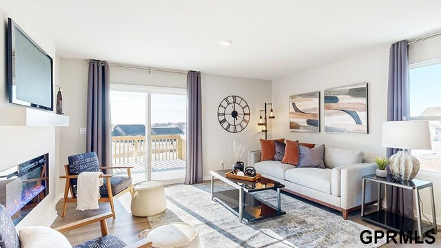 17650 Portal St, Omaha, NE 68136 - living area featuring wood finished floors and a glass covered fireplace
