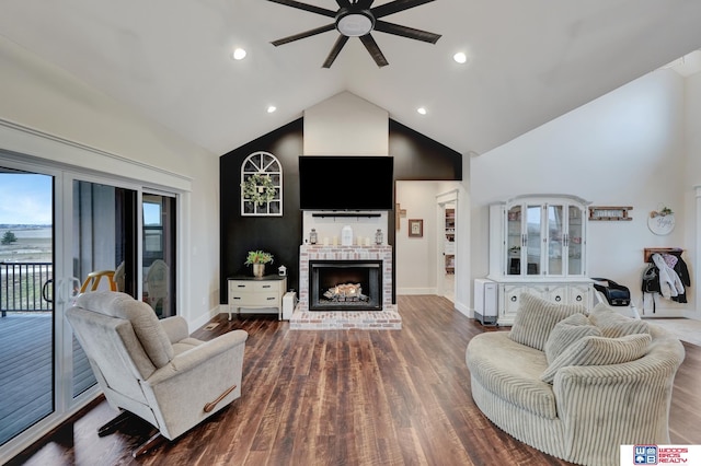 living area featuring high vaulted ceiling, baseboards, a ceiling fan, a fireplace, and wood finished floors