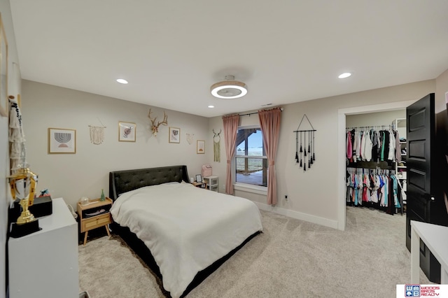 bedroom with light carpet, baseboards, recessed lighting, and a spacious closet