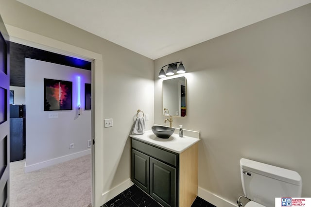 half bathroom featuring baseboards, toilet, and vanity