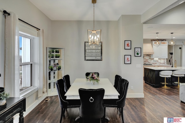 dining space featuring an inviting chandelier, dark wood-type flooring, baseboards, and visible vents
