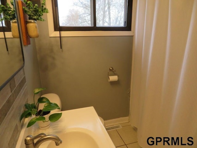 bathroom featuring tile patterned floors, a sink, and visible vents