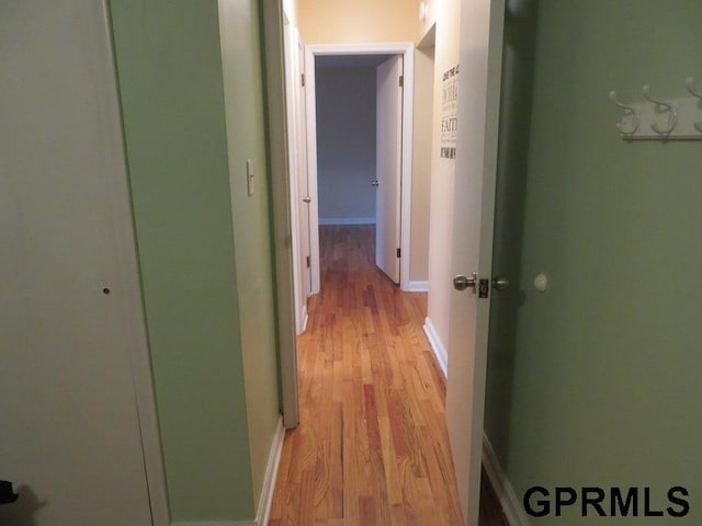 hall with light wood finished floors and baseboards