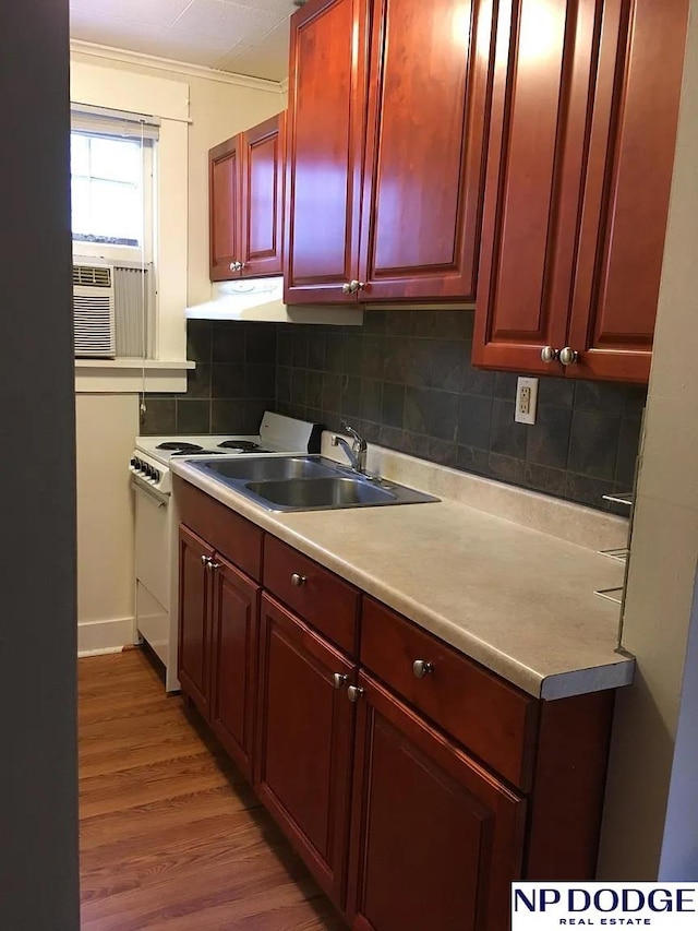 kitchen featuring light countertops, a sink, reddish brown cabinets, and decorative backsplash