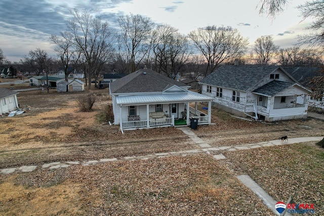 view of front of property with a shingled roof and a porch