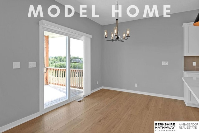 unfurnished dining area with baseboards, light wood-style flooring, visible vents, and an inviting chandelier