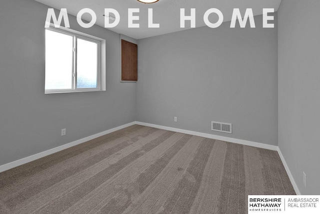 spare room with baseboards, carpet floors, and visible vents