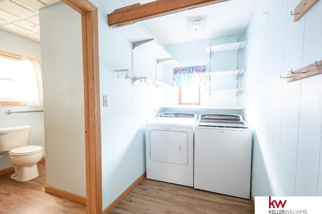 clothes washing area with washer and dryer, laundry area, and light wood finished floors