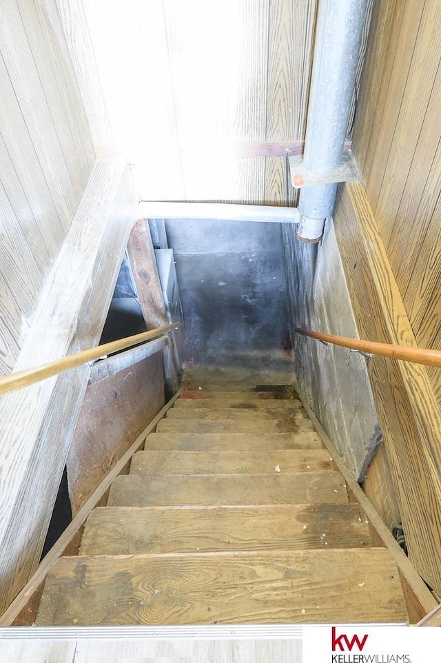 stairs featuring wood walls and hardwood / wood-style flooring