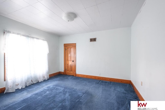 unfurnished room featuring carpet floors, baseboards, and visible vents