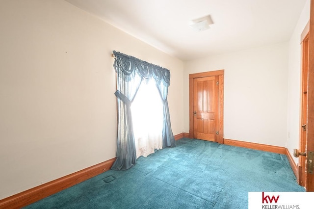 empty room with baseboards and carpet
