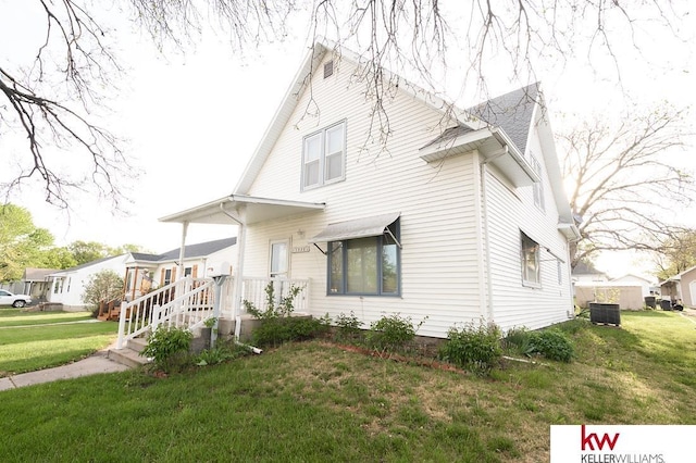 view of front of home featuring central AC and a front lawn