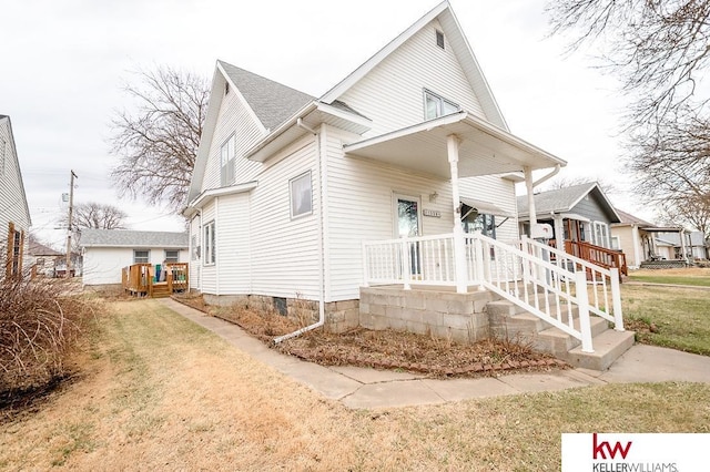 bungalow with covered porch, a front lawn, and crawl space