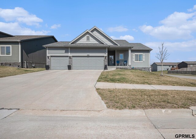 16604 Weber St, Bennington, NE 68007 - view of front of home with stone siding, driveway, a garage, and a front lawn