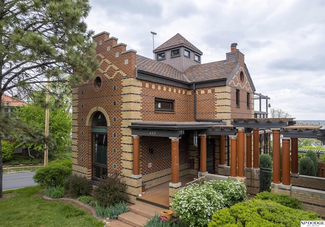 english style home featuring a chimney and brick siding