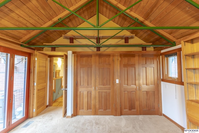 unfurnished bedroom featuring visible vents, carpet, vaulted ceiling, and wood ceiling