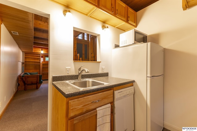 kitchen with dark countertops, dishwasher, a sink, wooden ceiling, and dark colored carpet
