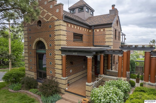 exterior space with brick siding, fence, and a chimney