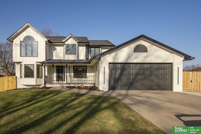 view of front of house with concrete driveway, a front lawn, fence, and an attached garage