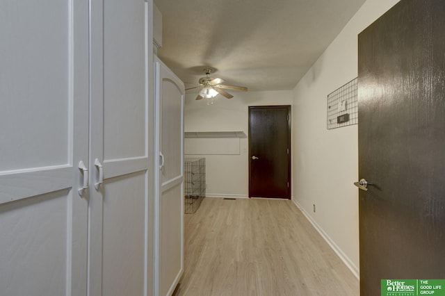 corridor with baseboards and light wood-type flooring